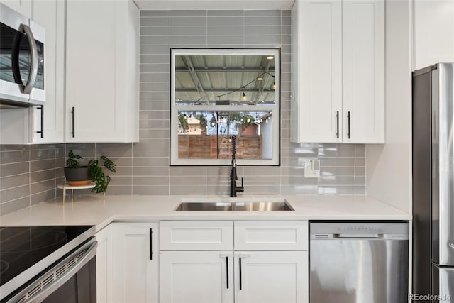 kitchen featuring white cabinetry, light countertops, a sink, and stainless steel appliances