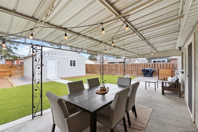 view of patio with an outdoor structure, a fenced backyard, and outdoor dining space