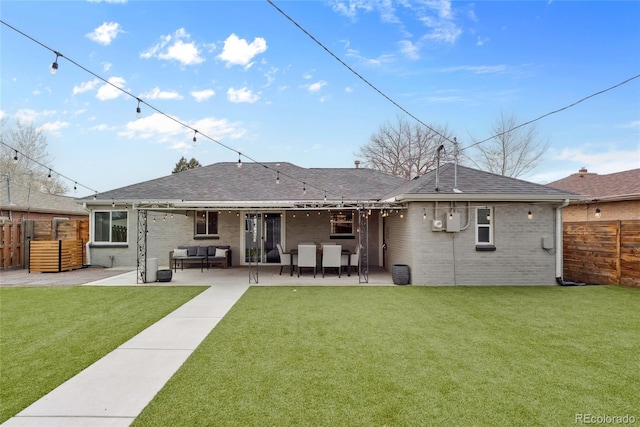 rear view of house featuring fence, a patio, an outdoor living space, brick siding, and a yard