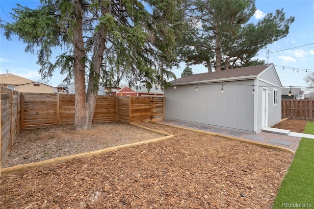 view of yard featuring a fenced backyard and an outdoor structure