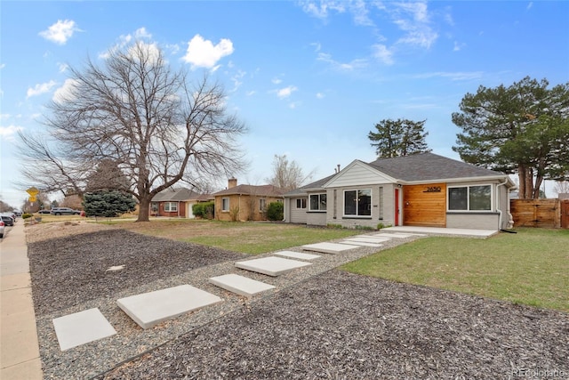 view of front of home with a front yard and fence