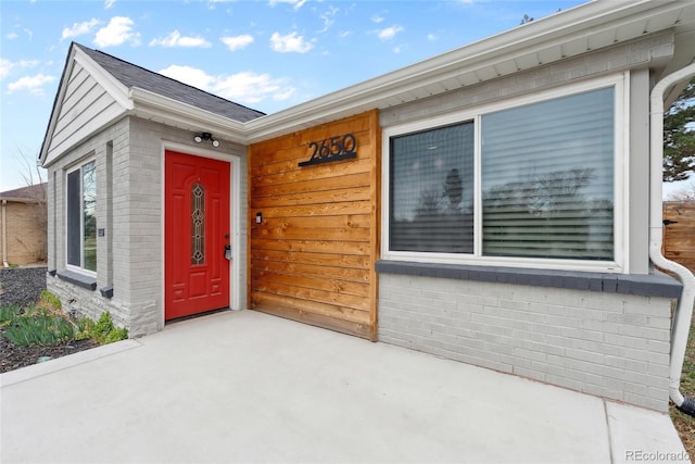 view of exterior entry featuring brick siding