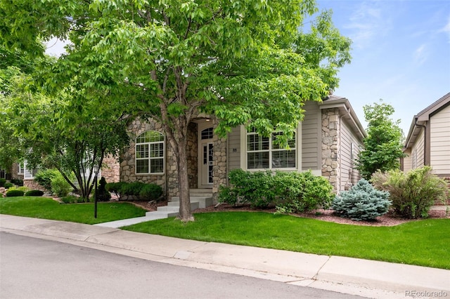6900 W Grant Ranch Blvd Unit 88, Denver, CO 80123 - obstructed view of property with stone siding and a front lawn