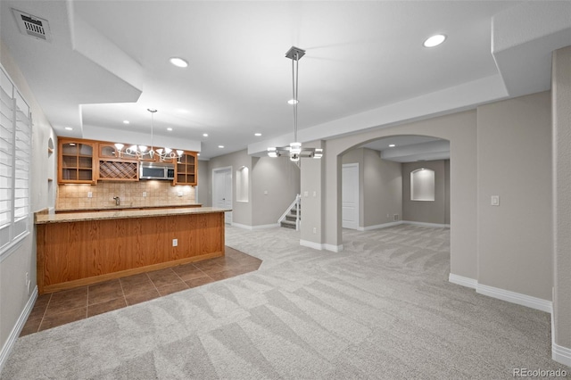 6900 W Grant Ranch Blvd Unit 88, Denver, CO 80123 - kitchen featuring stainless steel microwave, recessed lighting, brown cabinetry, glass insert cabinets, and light carpet