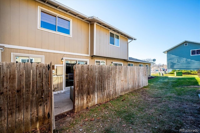 rear view of house featuring a yard and fence