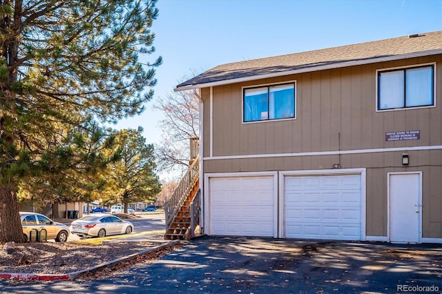 view of home's exterior featuring stairs, driveway, and a garage