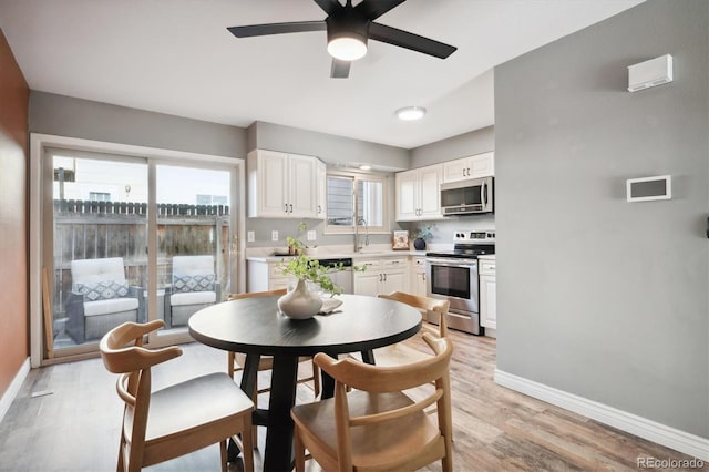 dining area featuring light wood finished floors, ceiling fan, and baseboards