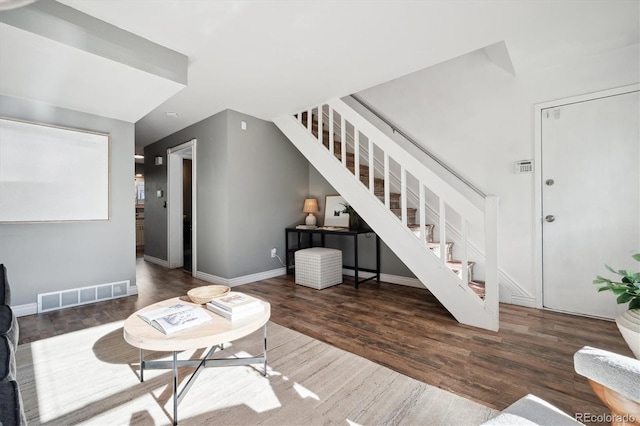 living room with stairs, wood finished floors, visible vents, and baseboards