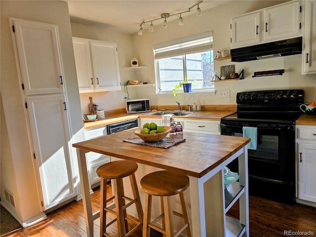 kitchen with white cabinets, a kitchen bar, sink, and black electric range