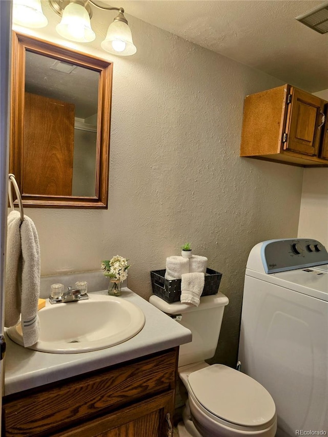 bathroom with washer / clothes dryer, vanity, and toilet