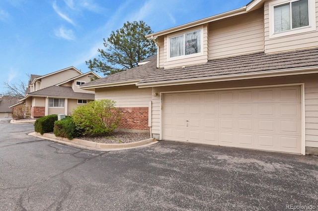 traditional-style home with brick siding, driveway, and a garage