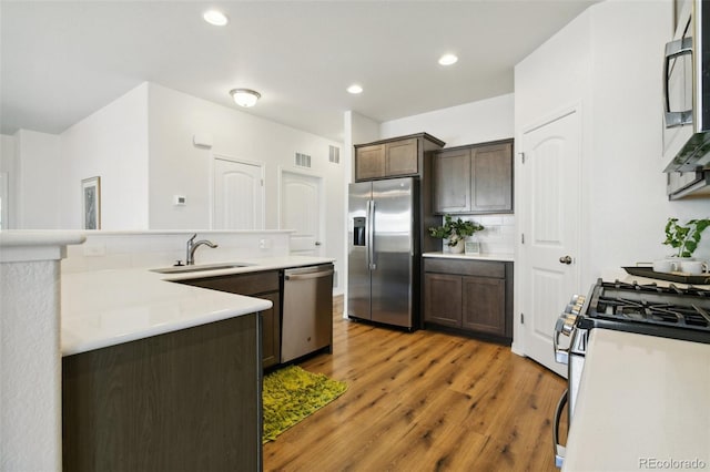 8339 Mosby Way, Colorado Springs, CO 80908 - kitchen with appliances with stainless steel finishes, light wood-type flooring, dark brown cabinets, light countertops, and decorative backsplash