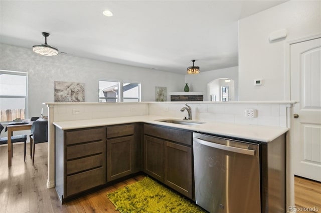 8339 Mosby Way, Colorado Springs, CO 80908 - kitchen with dishwasher, light countertops, arched walkways, wood finished floors, and hanging light fixtures