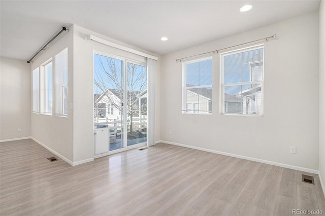 spare room with a wealth of natural light and light wood-type flooring