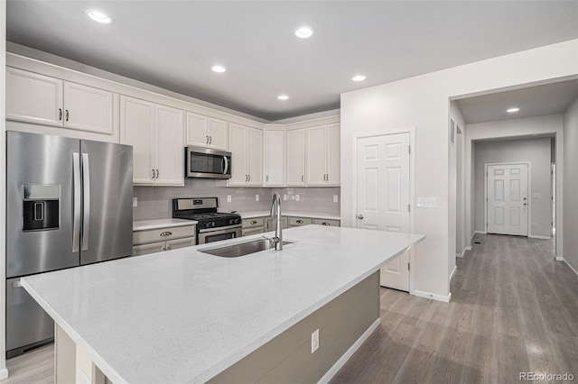 kitchen featuring sink, a center island with sink, white cabinets, and appliances with stainless steel finishes