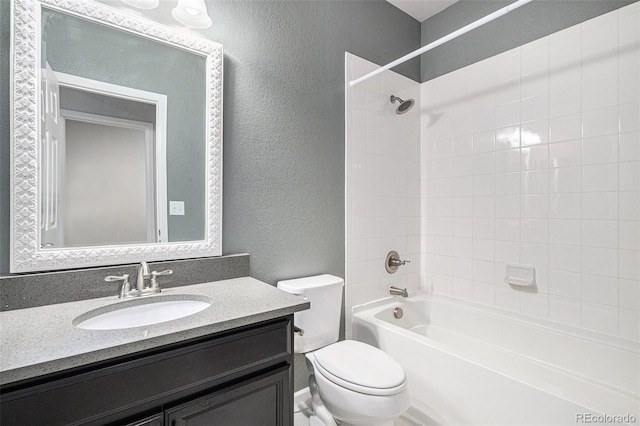 full bathroom with vanity, tiled shower / bath combo, and toilet