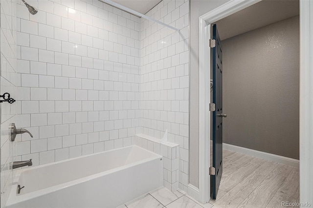 bathroom featuring tiled shower / bath combo and hardwood / wood-style flooring