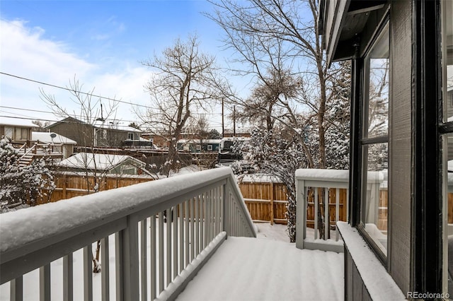 view of snow covered back of property