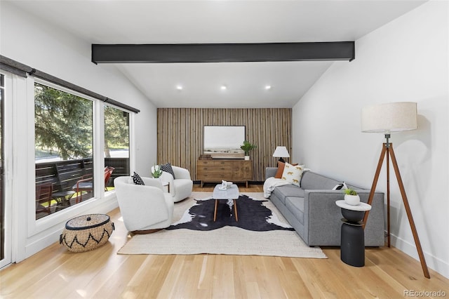 living room featuring hardwood / wood-style flooring, lofted ceiling with beams, and a healthy amount of sunlight