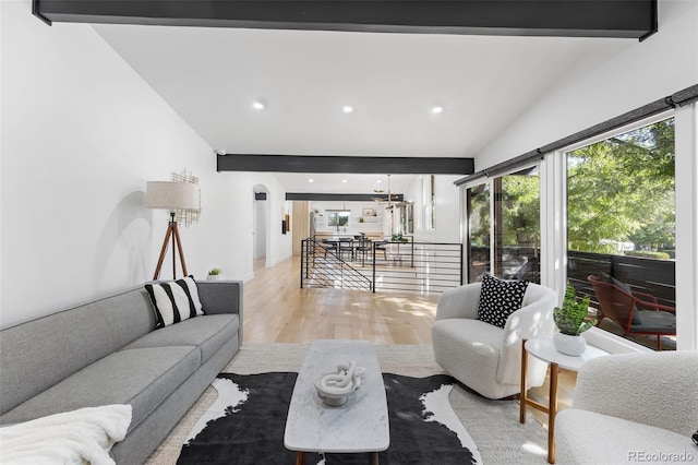 living room with vaulted ceiling with beams and light wood-type flooring