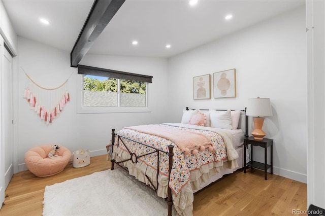 bedroom with wood-type flooring and lofted ceiling with beams