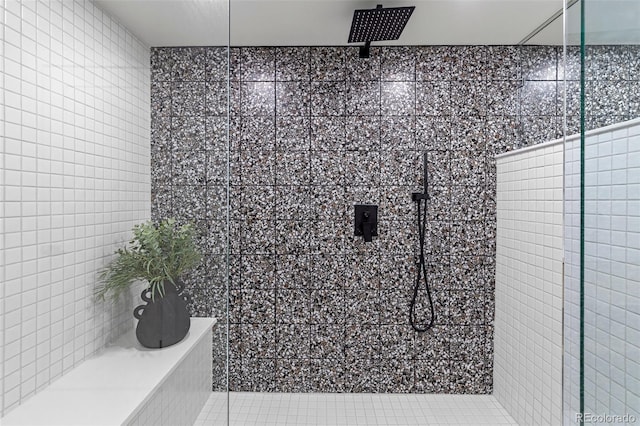 bathroom with tile patterned flooring, a shower, and tile walls