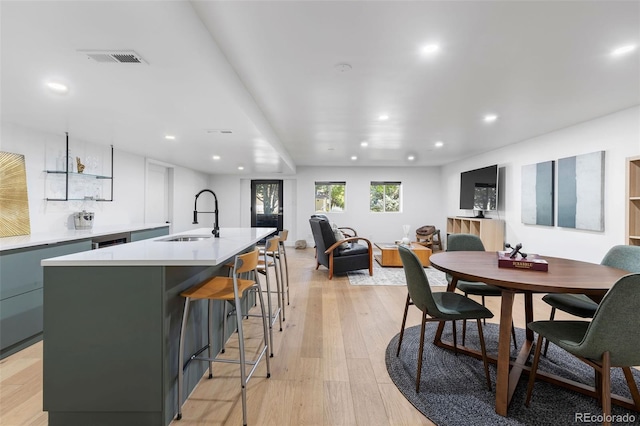 dining space with light wood-type flooring and sink