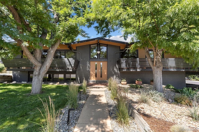 view of front of house featuring a front yard and a deck