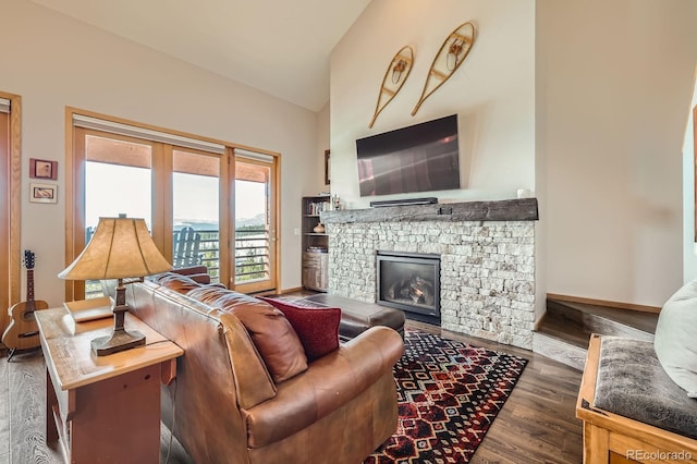 91400 Ryan Gulch Rd Unit 91427, Silverthorne, CO 80498 - living area with lofted ceiling, a stone fireplace, baseboards, and wood finished floors