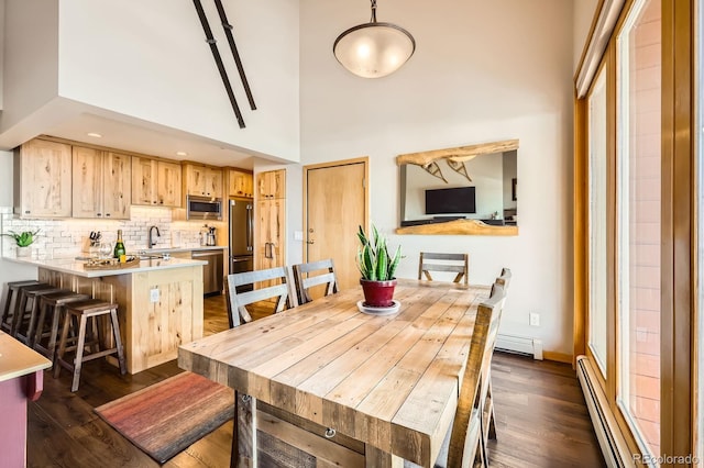 91400 Ryan Gulch Rd Unit 91427, Silverthorne, CO 80498 - dining room with a towering ceiling, baseboard heating, a baseboard radiator, and dark wood finished floors
