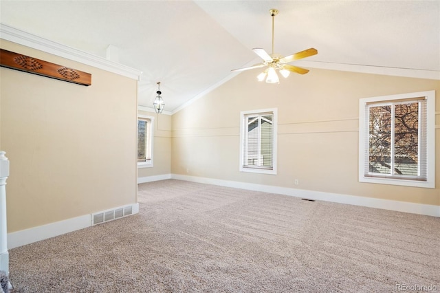 carpeted empty room featuring ceiling fan, ornamental molding, and vaulted ceiling