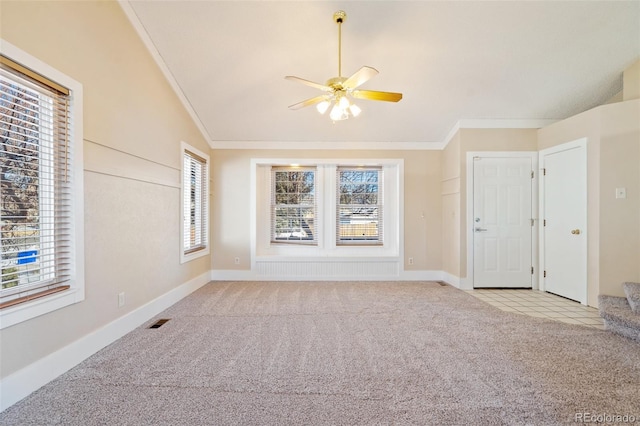 unfurnished living room featuring ceiling fan, light colored carpet, ornamental molding, and lofted ceiling