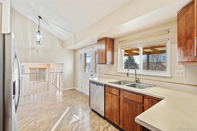 kitchen featuring appliances with stainless steel finishes, hanging light fixtures, vaulted ceiling, and sink