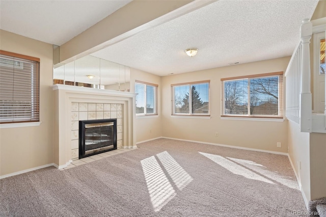 unfurnished living room featuring a fireplace, a textured ceiling, and light carpet