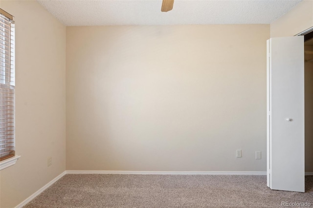 carpeted empty room with a textured ceiling