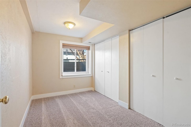 unfurnished bedroom with two closets and carpet