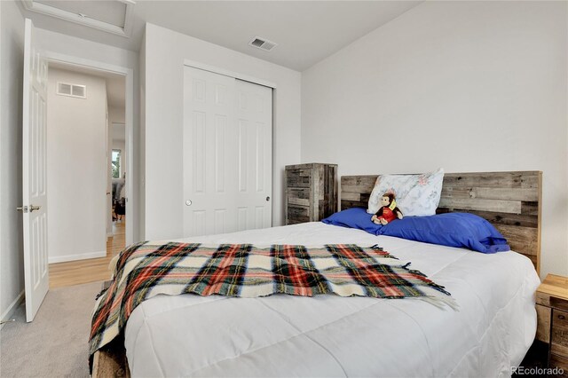 bedroom featuring baseboards, a closet, visible vents, and attic access