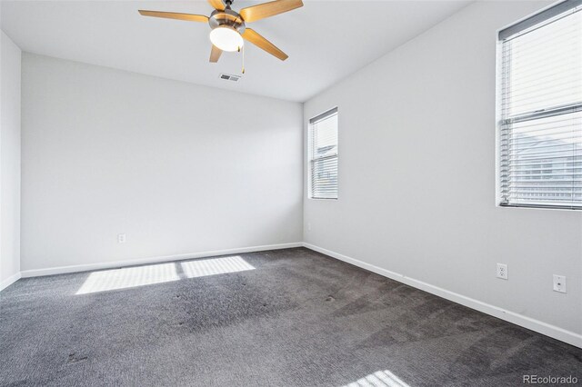 spare room featuring a ceiling fan, visible vents, baseboards, and carpet flooring