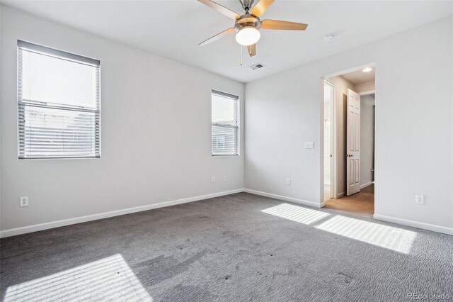 spare room with ceiling fan, carpet flooring, visible vents, and baseboards