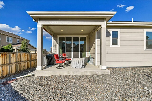 back of property featuring fence and a patio