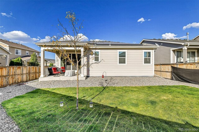 back of house with a yard, a fenced backyard, and a patio