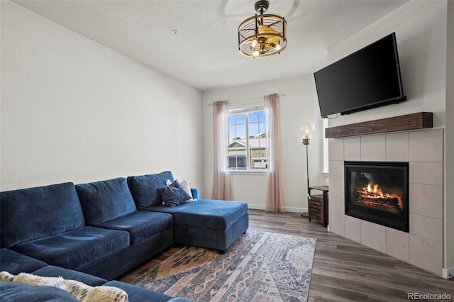 living room with a tiled fireplace and dark hardwood / wood-style floors