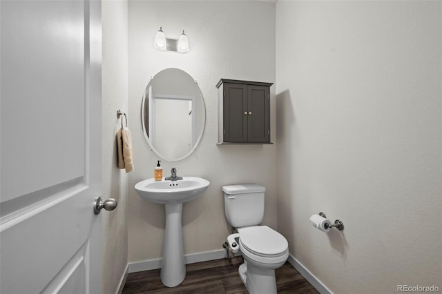 bathroom featuring hardwood / wood-style flooring, toilet, and sink