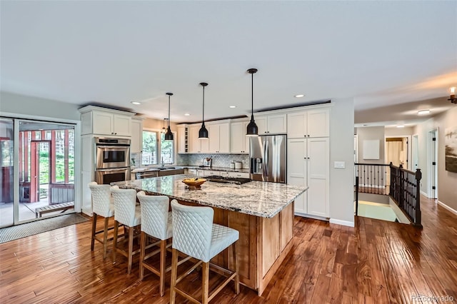 4776 Red Rock Dr, Larkspur, CO 80118 - kitchen with stainless steel appliances, a sink, a kitchen island, light stone countertops, and white cabinetry