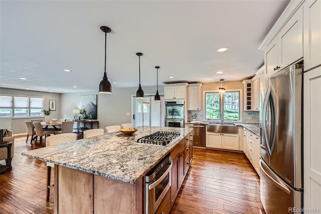 4776 Red Rock Dr, Larkspur, CO 80118 - kitchen with appliances with stainless steel finishes, a sink, plenty of natural light, a kitchen breakfast bar, and recessed lighting