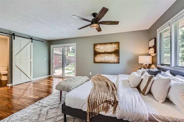 4776 Red Rock Dr, Larkspur, CO 80118 - bedroom with wood finished floors, access to exterior, a barn door, a ceiling fan, and baseboards