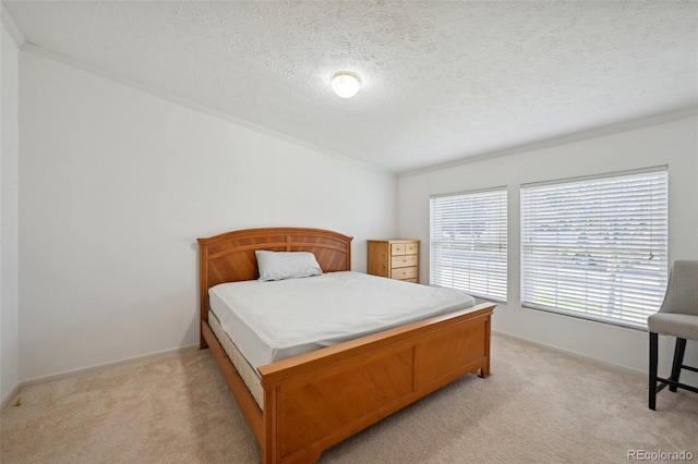 bedroom featuring ornamental molding, a textured ceiling, and light colored carpet