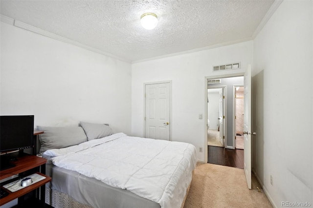 bedroom with carpet flooring, a textured ceiling, and ornamental molding