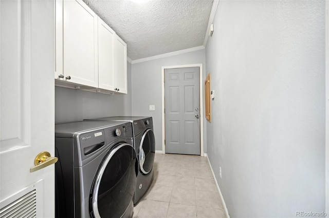 washroom with crown molding, separate washer and dryer, light tile patterned floors, a textured ceiling, and cabinets