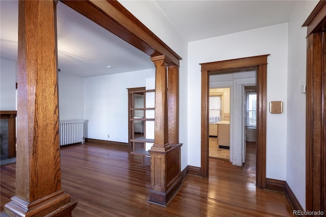 hall featuring dark hardwood / wood-style flooring and ornate columns